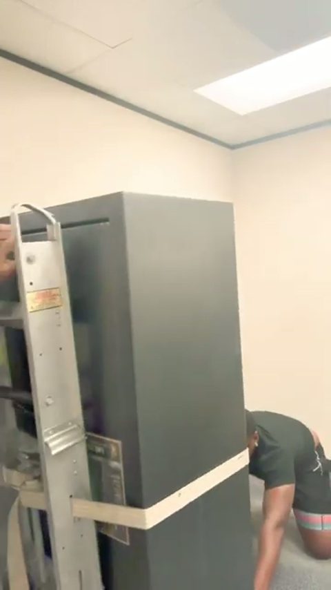 a heavy gun safe strapped upright on a stair-climbing hand truck ready to move